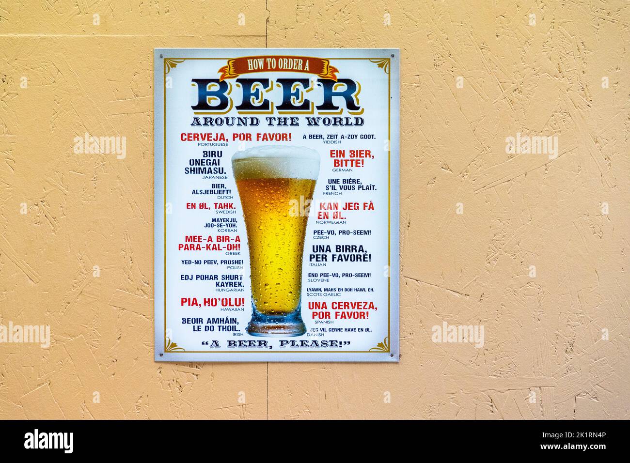 Ein farbenfrohes Plakat mit dem Titel „Wie man ein Bier in der ganzen Welt bestellt“ hängt an der gelben Wand der Brauerei Naùera in Lousteau in der Nähe von Saint-Laurent-Médoc, Médoc, Frankreich, und listet Phrasen zum Bierbestellen in mehr als einem Dutzend Sprachen auf. Die kleine familiengeführte Brauerei produziert seit ihrer Gründung Craft-Biere und Bieressige aus dem Médoc. Stockfoto