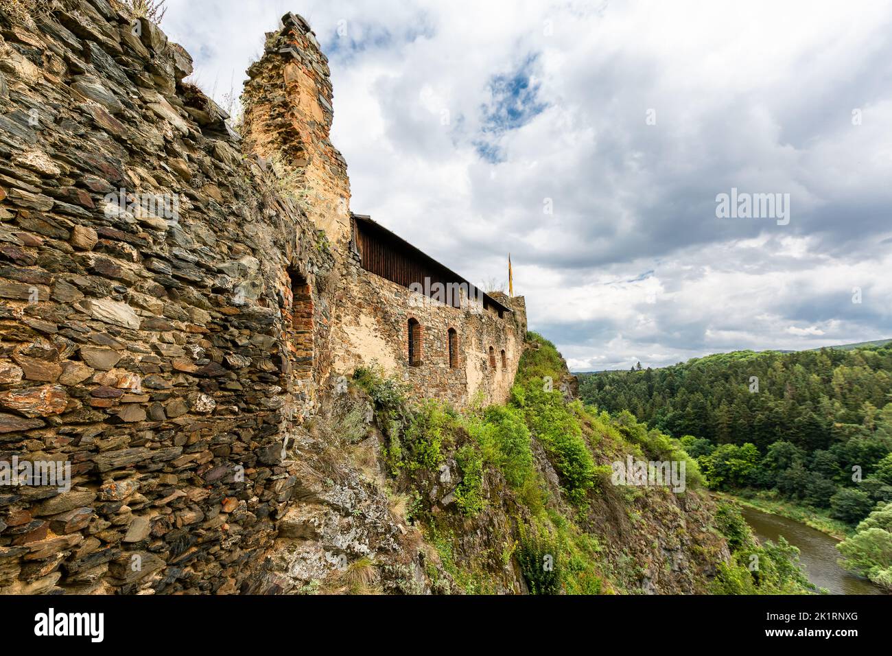 Krasov, Tschechische Republik - Juli 30 2022: Blick auf die Steinmauer der mittelalterlichen Burg, die im 13.. Jahrhundert auf einem steilen Felsen erbaut wurde. Grüner Wald im Hintergrund Stockfoto