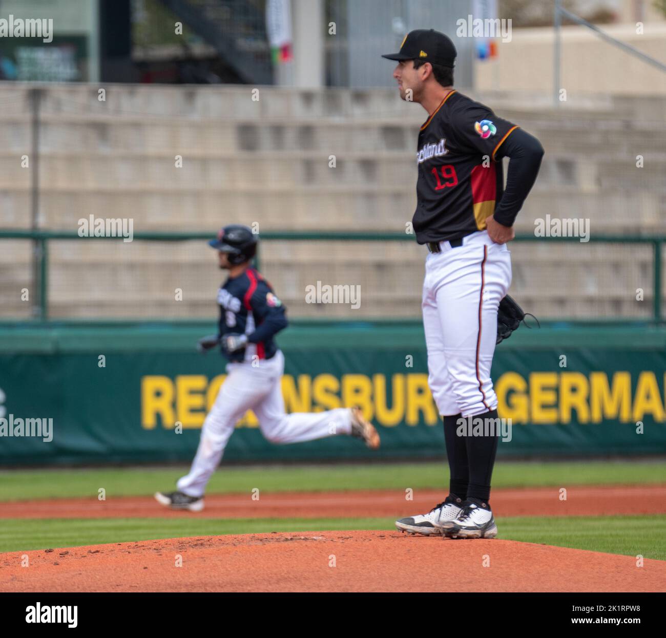 20. September 2022, Regensburg, Bayern, Deutschland: Deutschland Pitcher TOMMY SOMMER (19, rechts) sieht zu, wie PETR ZYMA (9, links) nach einem Heimlauf in der World Baseballclassic-Qualifikation in der Armin Wolf Baseballarena in Regensburg um die Basen trabt. (Bild: © Kai Dambach/ZUMA Press Wire) Stockfoto