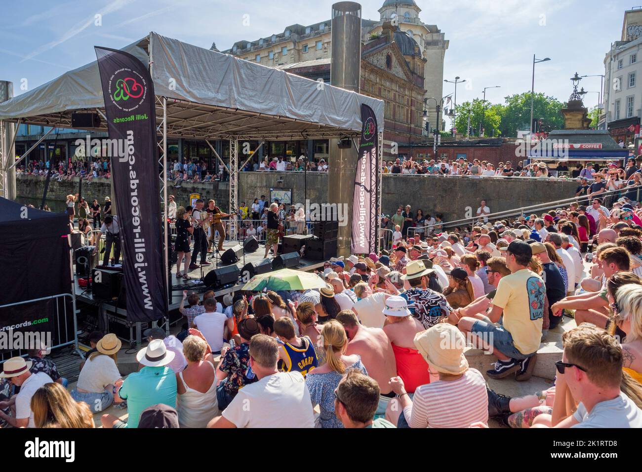 Menschen, die Live-Musik genießen, die auf der Center Stage der Cascade Steps während des Bristol Harbour Festivals 2022 in England, Großbritannien, aufgeführt wird. Stockfoto