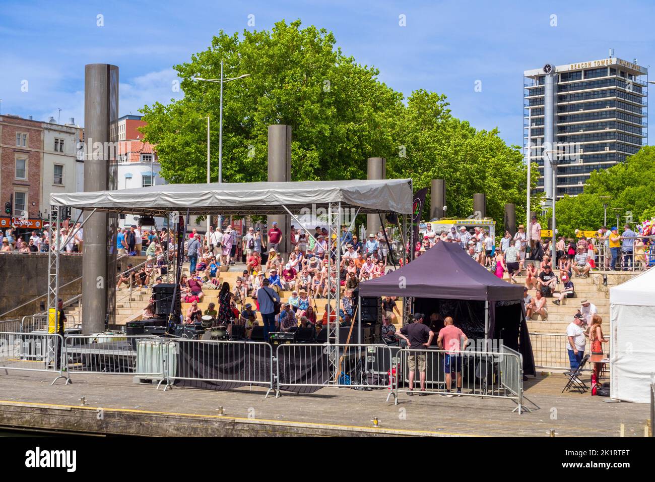 Menschen, die Live-Musik genießen, die auf der Center Stage der Cascade Steps während des Bristol Harbour Festivals 2022 in England, Großbritannien, aufgeführt wird. Stockfoto