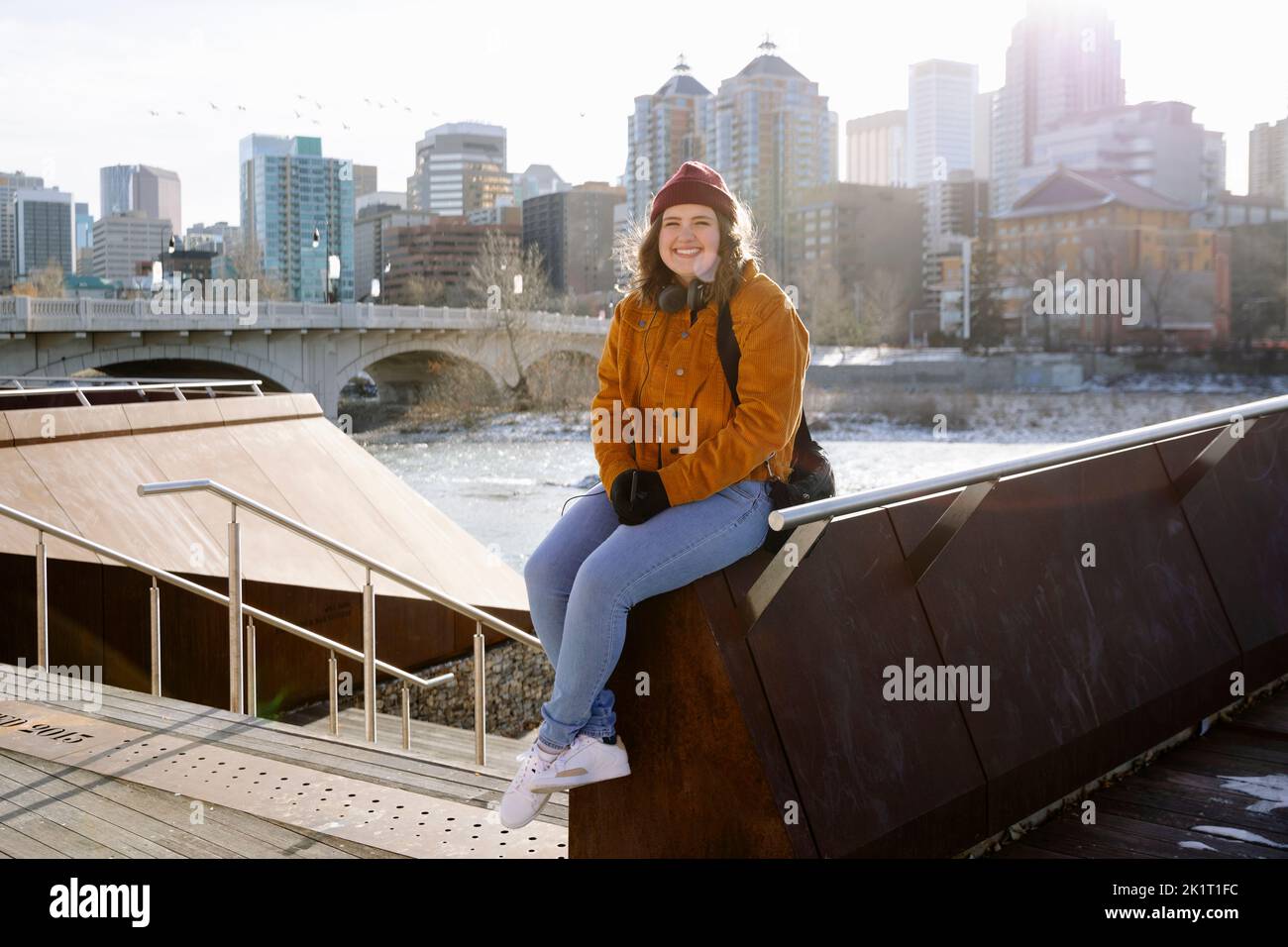 Portrait glückliche junge Frau im sonnigen Winter Stadtpark Stockfoto