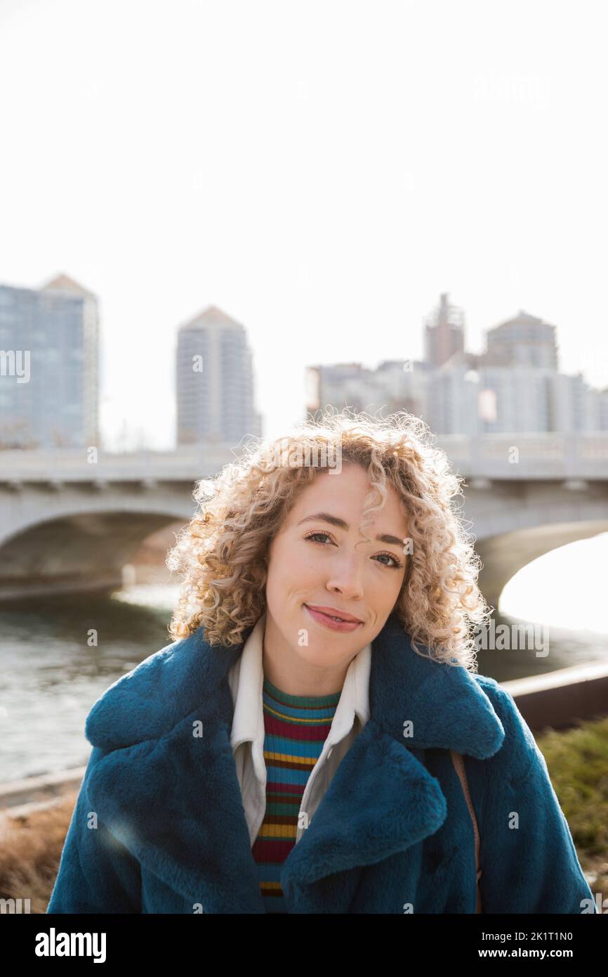 Porträt selbstbewusste junge Frau in sonniger Stadt Stockfoto