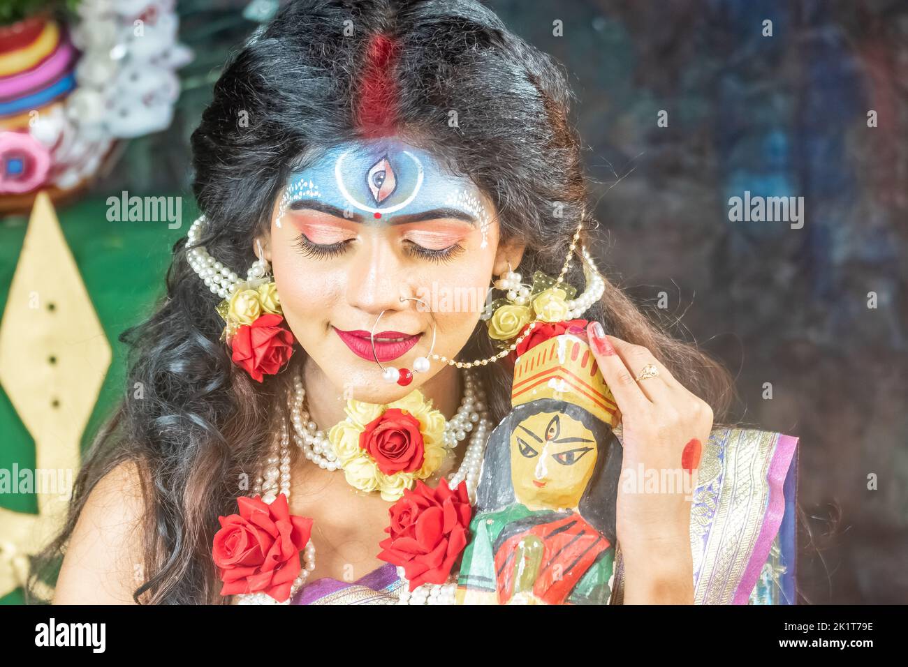 Konzept Agomoni Shoot mit schwarz haarigen indischen Brünette Frau Gesicht mit perfektem Make-up und tragen Juweliere mit traditionellen Kleid wie Göttin Stockfoto