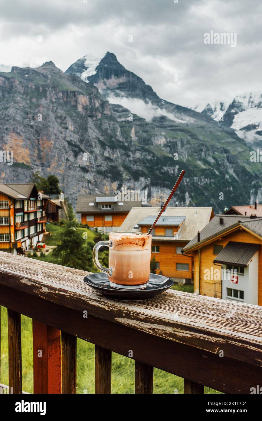 Schweiz, Jungfrau. Schweizer Alpen. Gemütliches traditionelles kleines Dorf in den Bergen. Cafeterrasse. Heiße Tasse Kaffee am Morgen. Stockfoto