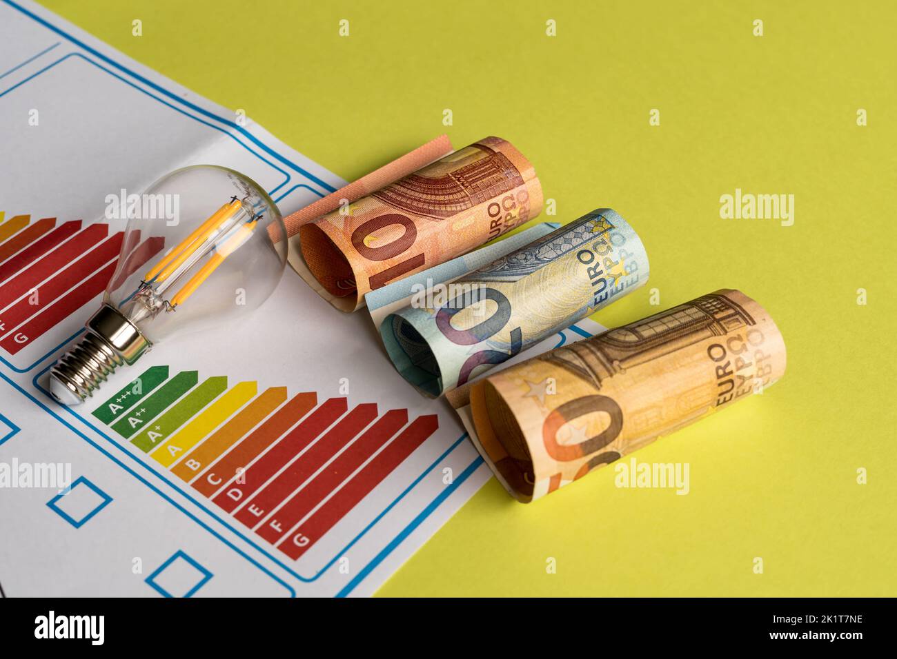 Konzept der Energieeffizienz übersetzt in die Kosten in Rechnungen, die die Verbesserung der elektrischen Geräte des Hauses auf grünem Hintergrund darstellt Stockfoto