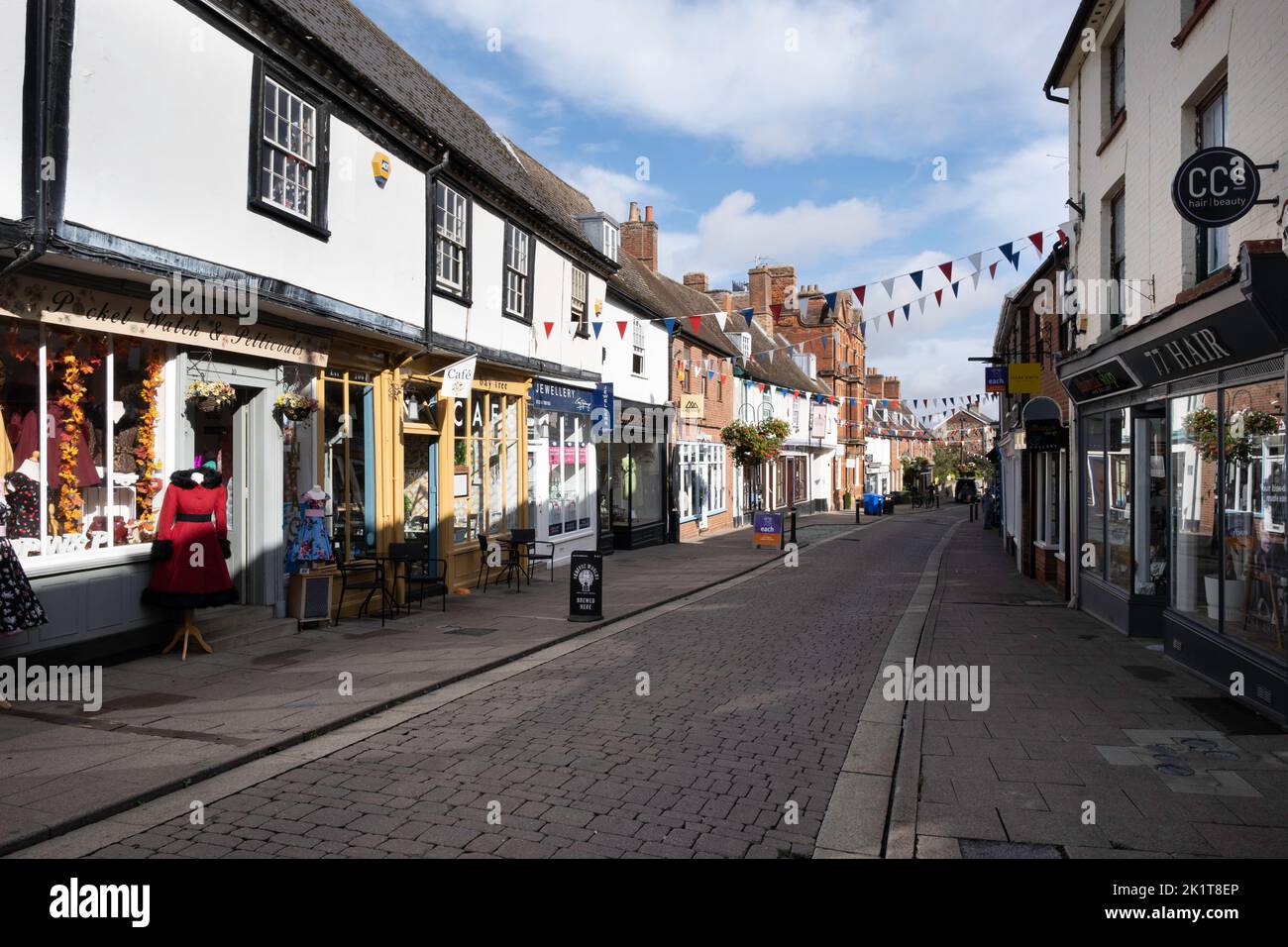 Auf der mit Flaggen geschmückten St John's Street in Bury Saint Edmunds, Oxfordshire, Großbritannien, gehen Menschen spazieren und einkaufen Stockfoto