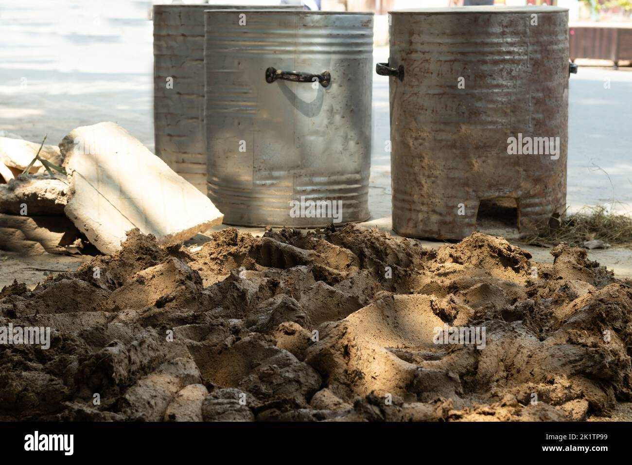 Gemischter Mitti-Ton mit Weizenstrohholz, Hay Bhoosa und besprühtem Wasser, um zylindrischen Topf für die Herstellung von indischen DIY Clay Ofen auch als D vorzubereiten Stockfoto