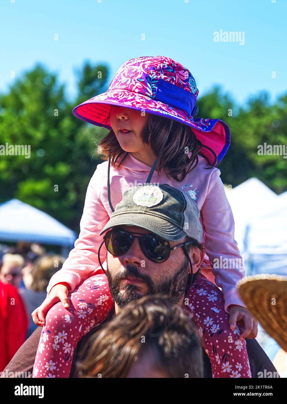Ein junges Mädchen auf den Schultern ihres Vaters beim jährlichen Cranberry Festival in Harwich, Massachusetts, Cape Cod, USA Stockfoto