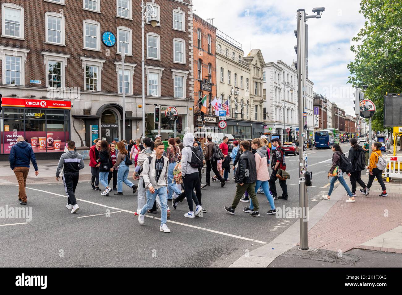 Fußgänger, die eine Straße mit einer Fußgängerüberführung im Stadtzentrum von Dublin, Irland, überqueren. Stockfoto