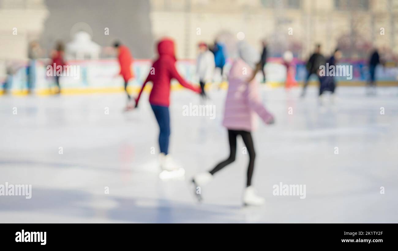 Verschwommener abstrakter Winterhintergrund. Teenager Freundinnen Eislaufen im Stadtpark Stockfoto