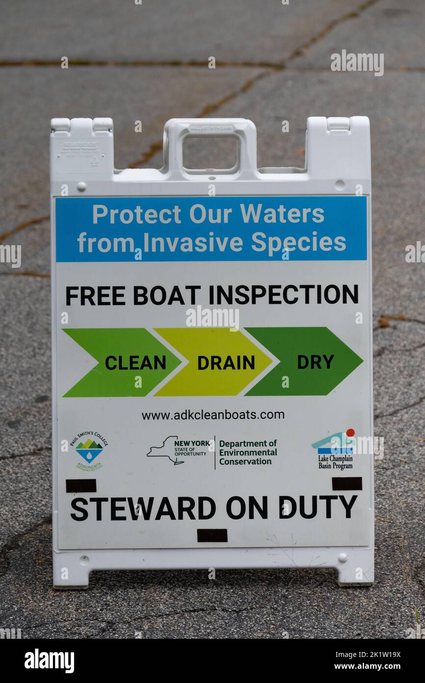 Ein Schild, das einen Steward ankündigt, der für die kostenlose Bootskontrolle zum Schutz der Gewässer vor invasiven Arten in den Adirondack Mountains, NY, im Dienst ist Stockfoto