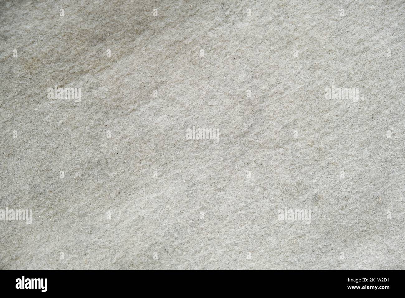 Die Textur von weißem Filz. Silberfarbener Hintergrund. Fühlte sich an wie Schnee. Stockfoto