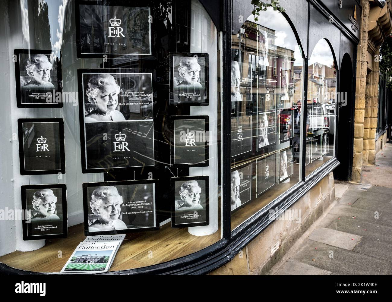 Schwarz-Weiß-Portraitbilder der Königin Elizabeth 2. in einem geschwungenen Schaufenster in der Marktstadt Alnwick, Northumberland, England. Stockfoto