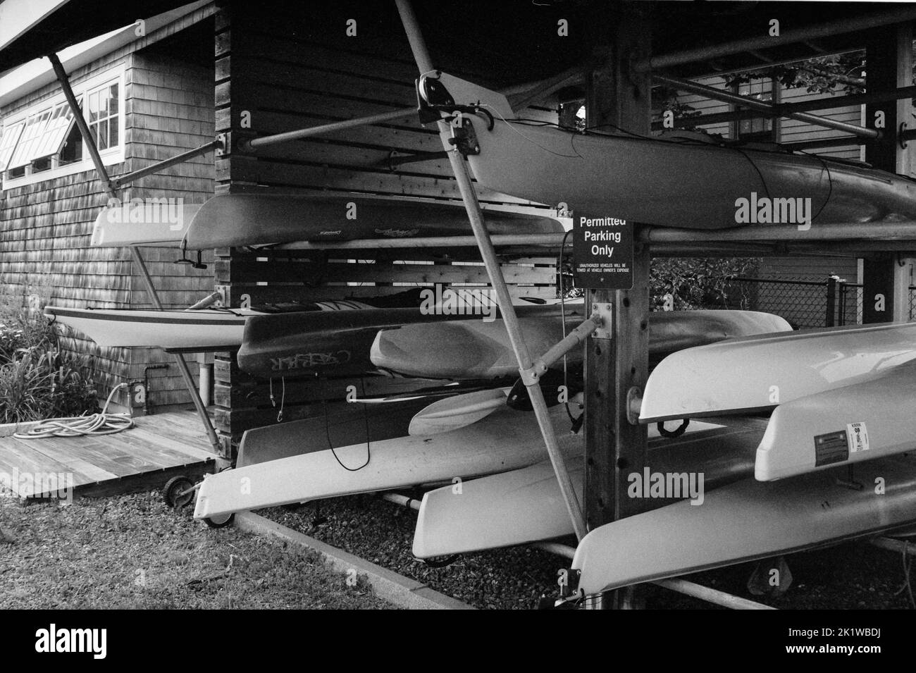 Kajaks, gestapelt in einem Rack auf einem privaten Dock am Rocky Neck Gloucester, Massachusetts. Das Bild wurde auf analogem Schwarzweiß-Film aufgenommen. Stockfoto