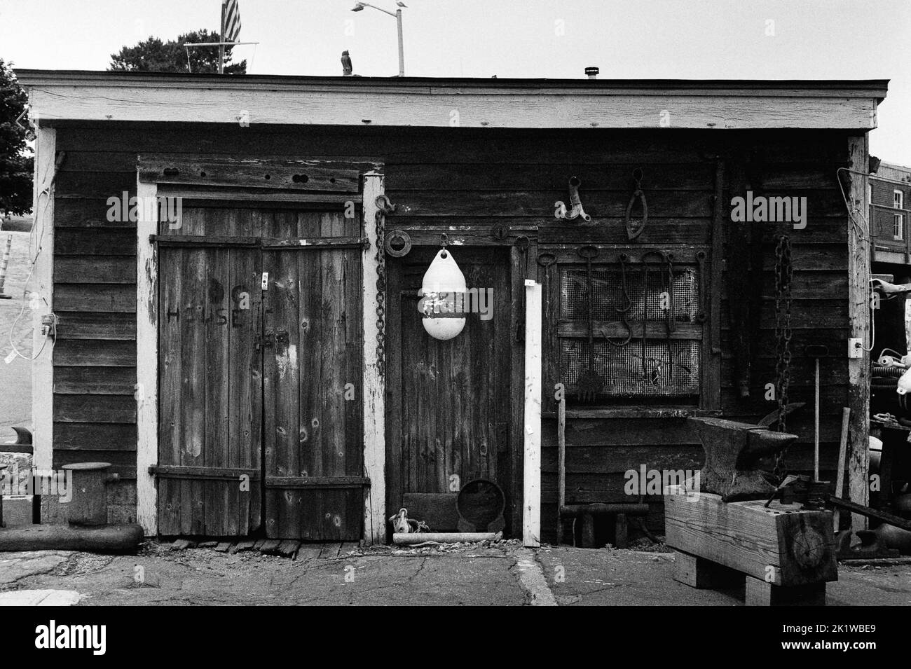 The Dog House - ein verwitterter Holzschuppen an den Docks in Gloucester Harbour, Massachusetts. Das Bild wurde auf analogem Schwarzweiß-Film aufgenommen. Stockfoto