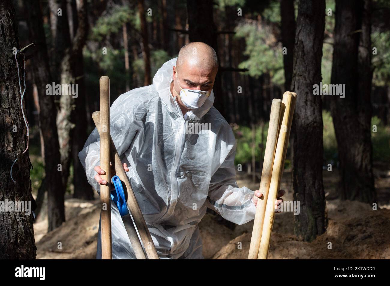 Izium, Ukraine. 19. September 2022. Mitglied des ukrainischen Notdienstes arbeitet an einem Ort der Massenbestattung während der Exhumierung in der Stadt Izium, die kürzlich von ukrainischen Streitkräften befreit wurde, im Gebiet Charkiw. Nach der Einsetzung der Stadt Izium durch ukrainische Truppen wurde eine Massenbestattung gefunden. Kredit: SOPA Images Limited/Alamy Live Nachrichten Stockfoto