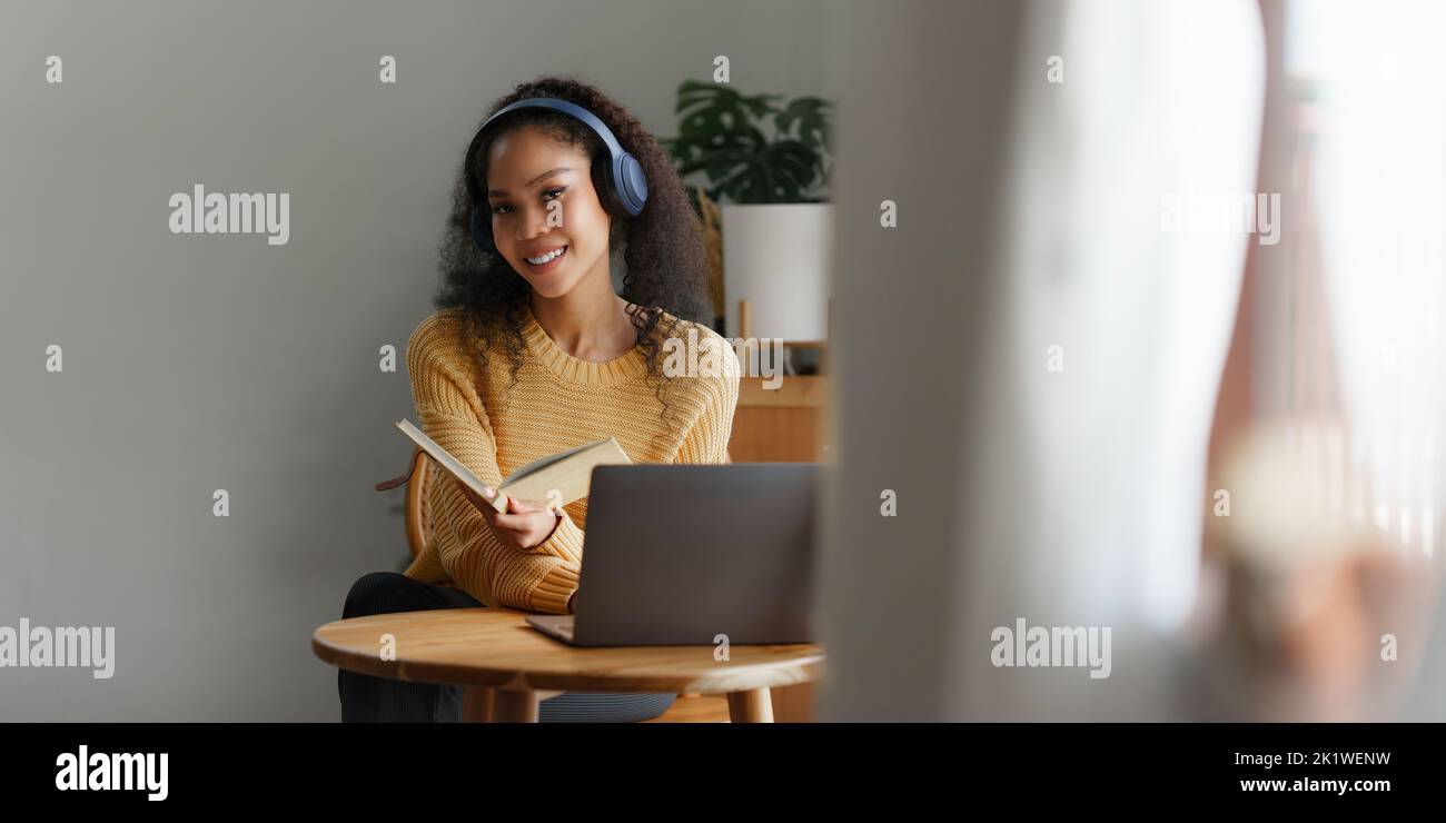 Schöne Frau mit Laptop und Musik hören mit Ohrhörern Stockfoto