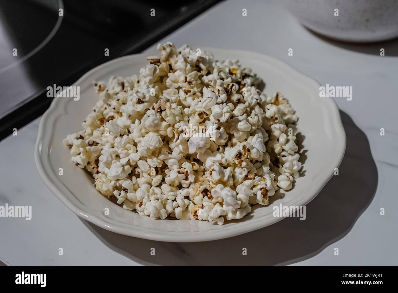 Popcorn in eine Schüssel geben Stockfoto