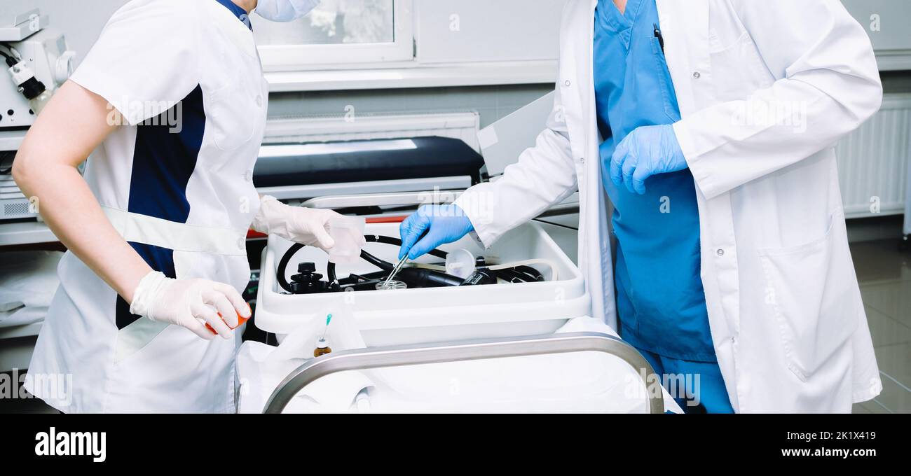 Arzthände in sterilen Handschuhen mit Pinzette. Ein Arzt mit einer Pinzette nimmt nach einer Koloskopie ein Fragment menschlichen Gewebes zur Biopsie und histologischen Analyse. Stockfoto