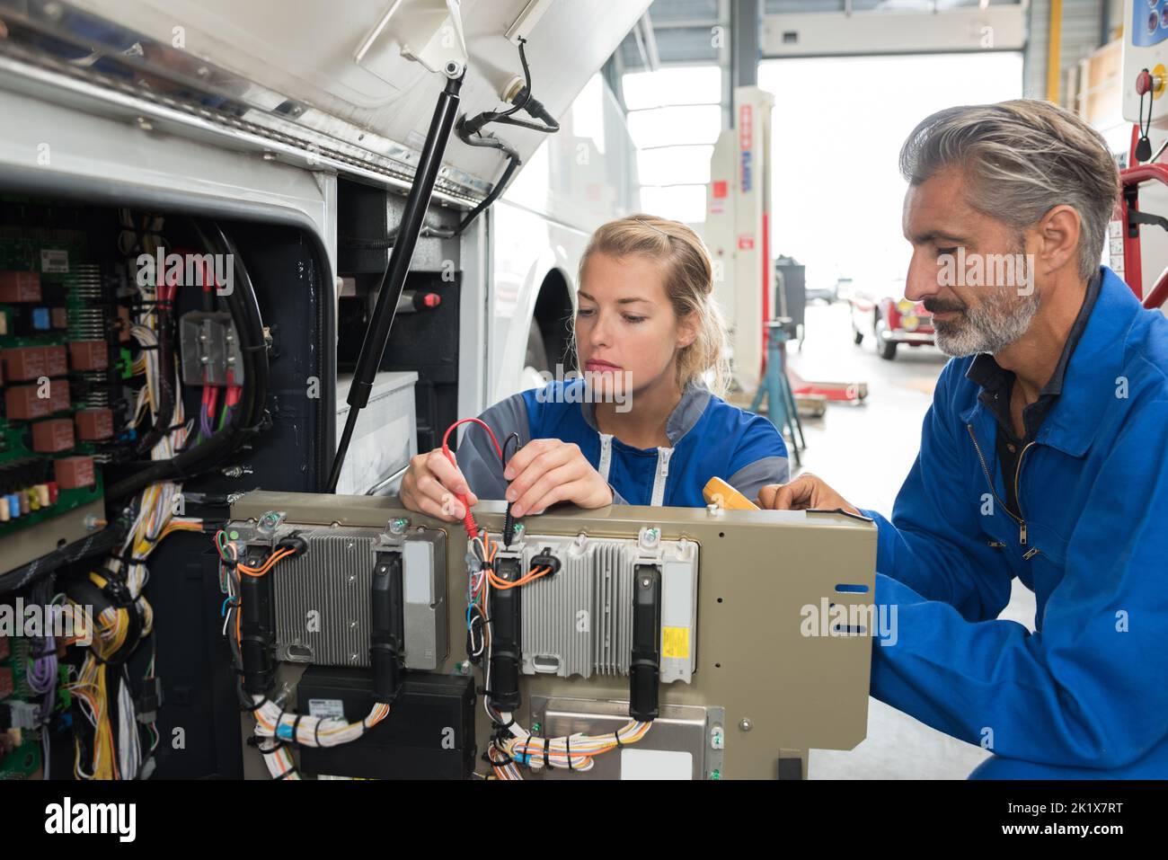 Mechaniker, die an der Elektronik eines Busses arbeiten Stockfoto