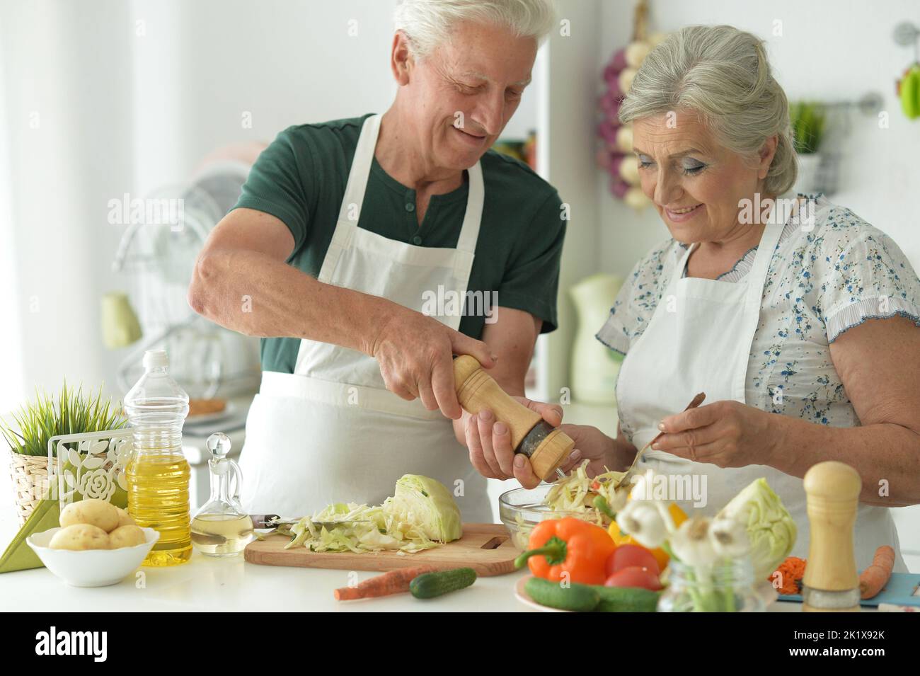 Schönes älteres Paar, das Salat in der Küche zubereitet Stockfoto