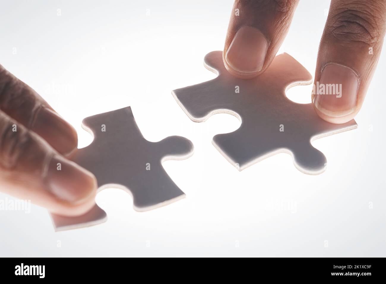 Alles fällt an Ort und Stelle. Hände halten zwei Puzzleteile. Stockfoto