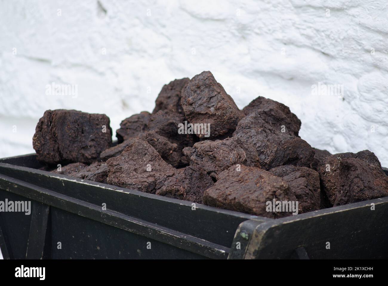 Schneiden Sie Torf aus einem Torfmoor, das bereit ist, im Kamin zu brennen. Torfscheiben, die getrocknet und bereit sind, ein Ferienhaus zu heizen und oben zu kochen. Stockfoto