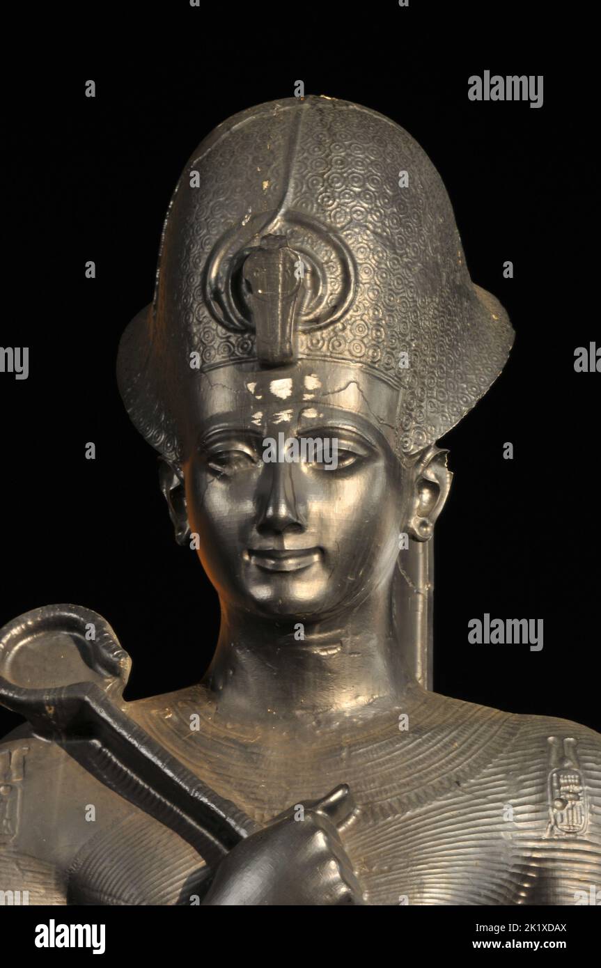 Eine vertikale Nahaufnahme der Statue von König Ramses II., isoliert auf dem schwarzen Hintergrund. Stockfoto