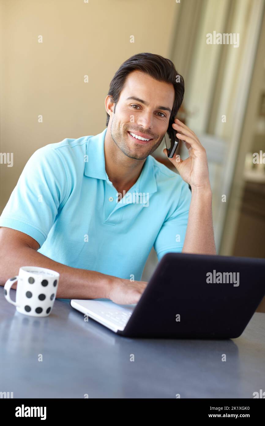 Networking von zu Hause aus. Ein hübscher Mann, der zu Hause mit seinem Laptop telefoniert. Stockfoto