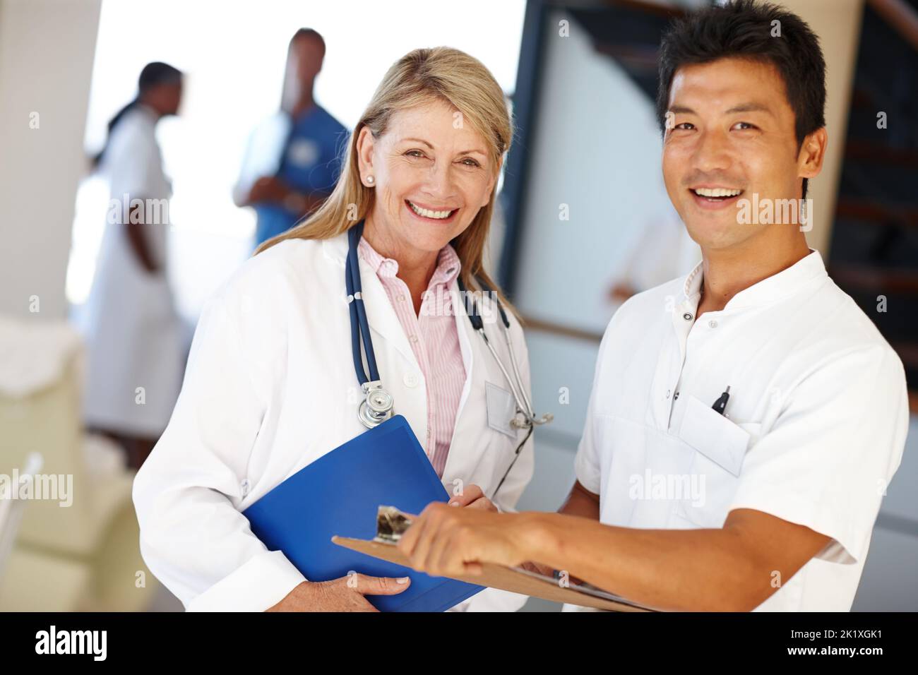 Halten Sie uns weg essen einen Apfel. Zwei medizinische Fachkräfte lächeln an der Kamera. Stockfoto