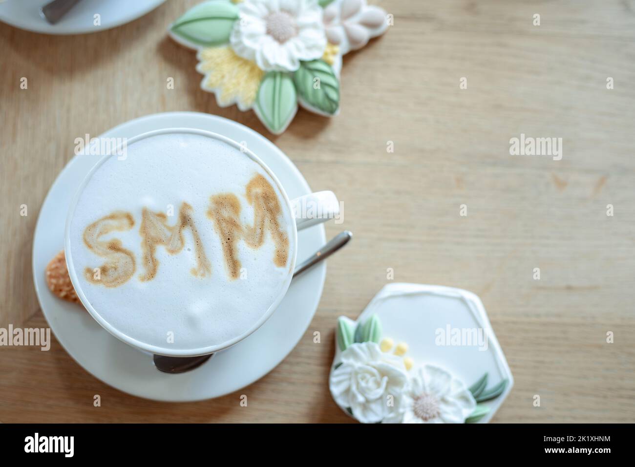 Foto Draufsicht auf Tasse heißen aromatisierten Kaffee mit weißem Schaum und schöne Puderkekse auf dem Tisch, freie Kopie Platz, Holzhintergrund. Soziale Medien Stockfoto