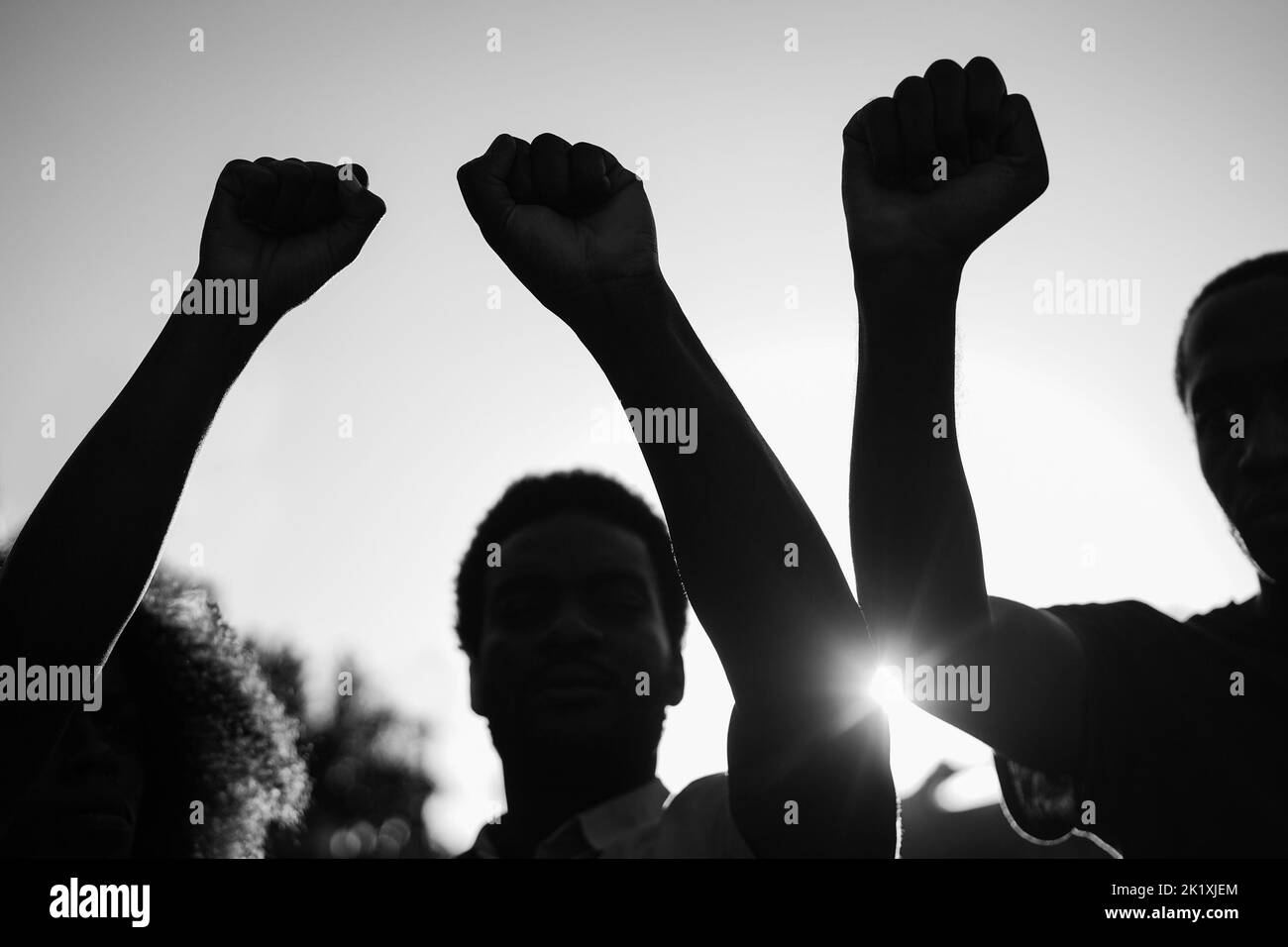 Schwarze Demonstranten halten Hände gegen Rassismus - Fokus auf Fäuste - Schwarz-Weiß-Schnitt Stockfoto