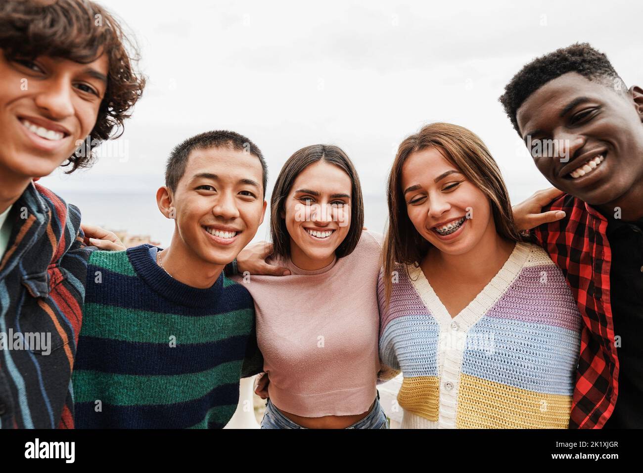 Portrait von multirassischen Freunden mit Spaß lächeln vor der Kamera im Freien - Fokus auf Mitte Mädchen Gesicht Stockfoto