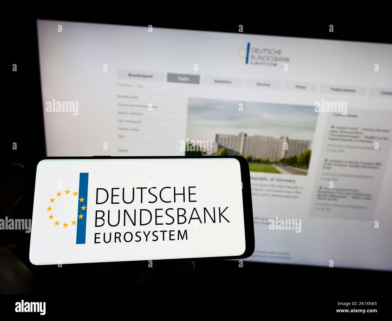 Person, die das Smartphone mit dem Logo der Deutschen Bundesbank auf dem Bildschirm vor der Website hält. Konzentrieren Sie sich auf die Telefonanzeige. Stockfoto