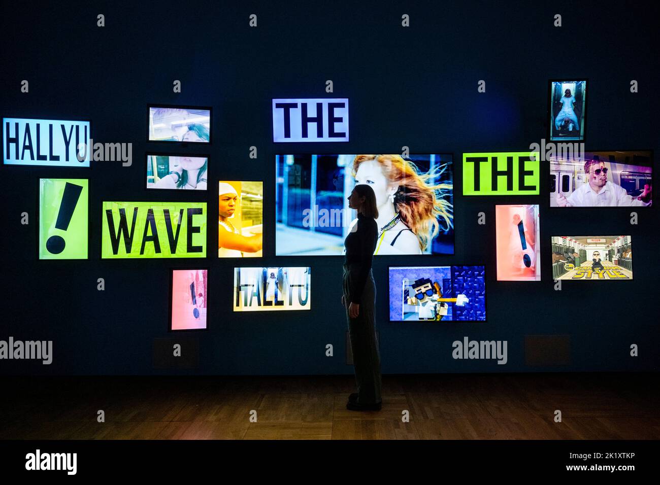 London, Großbritannien. 21. September 2022. Ein Mitarbeiter posiert mit Bildschirmen, die ein Video vom „Gangnam-Stil“ von PSY am Eingang von „Hallyu! The Korean Wave“ im V&A Museum in South Kensington, der ersten Ausstellung dieser Art, die die farbenfrohe und dynamische Populärkultur Südkoreas feiert. Die Show beginnt am 24. September bis 25. Juni 2023. Kredit: Stephen Chung / Alamy Live Nachrichten Stockfoto