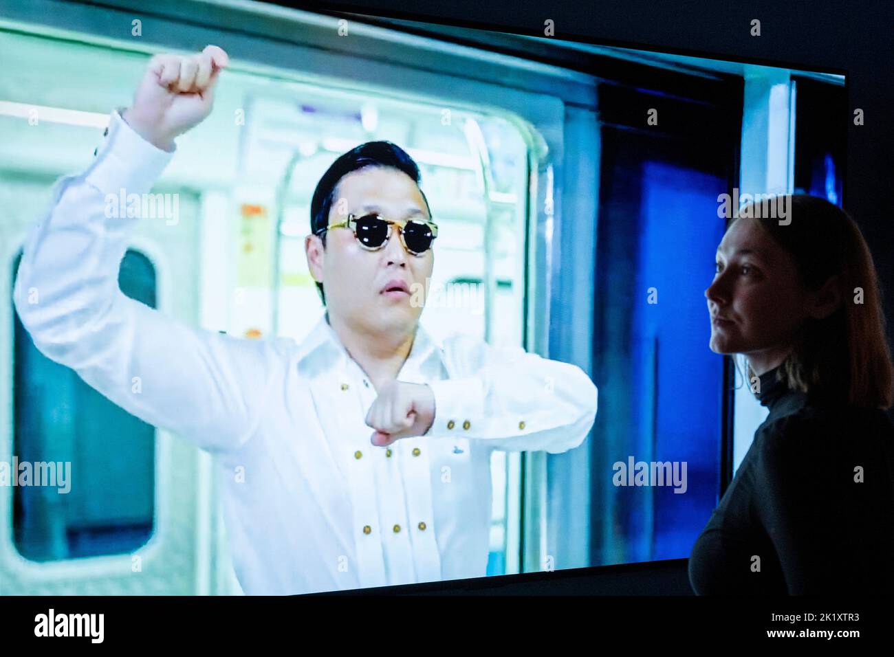 London, Großbritannien. 21. September 2022. Ein Mitarbeiter posiert mit Bildschirmen, die ein Video vom „Gangnam-Stil“ von PSY am Eingang von „Hallyu! The Korean Wave“ im V&A Museum in South Kensington, der ersten Ausstellung dieser Art, die die farbenfrohe und dynamische Populärkultur Südkoreas feiert. Die Show beginnt am 24. September bis 25. Juni 2023. Kredit: Stephen Chung / Alamy Live Nachrichten Stockfoto