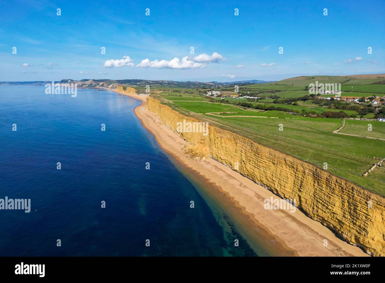 Blick aus der Luft auf die goldenen Sandsteinklippen am Bienenstrand von Burton Bradstock an der Dorset Jurassic Coast an einem heißen, sonnigen Herbsttag. Stockfoto
