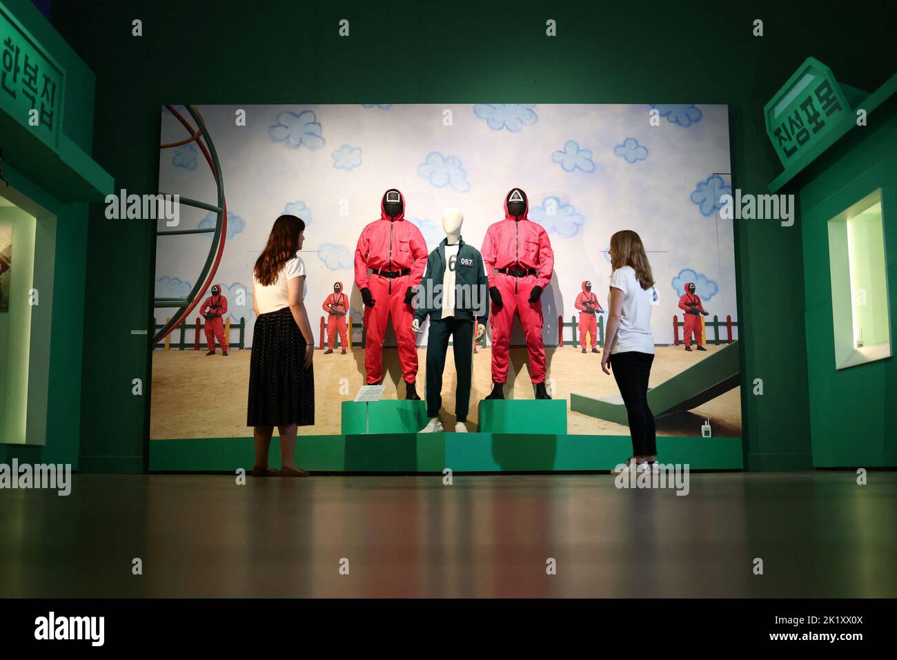 Die Mitarbeiter der Galerie schauen sich „Storytelling through costumes: Squid Game“ während der Presseansicht von „Hallyu! The Korean Wave' Ausstellung auf der V&A in London, Großbritannien, 21. September 2022. REUTERS/Tom Nicholson Stockfoto