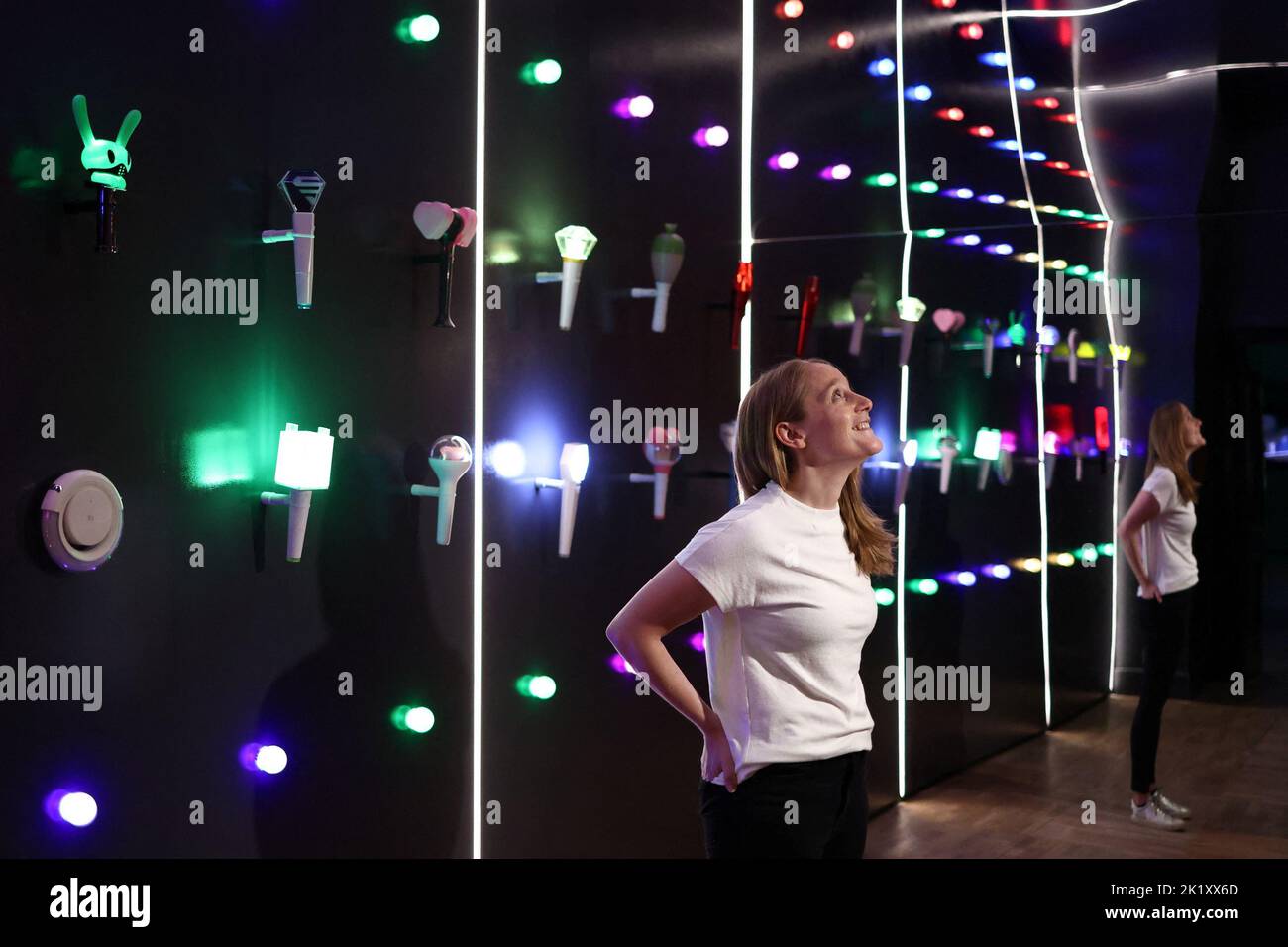 Ein Galerie-Assistent betrachtet „K-POP Lightsticks“ während einer Presseinsicht von „Hallyu! The Korean Wave' Ausstellung auf der V&A in London, Großbritannien, 21. September 2022. REUTERS/Tom Nicholson Stockfoto