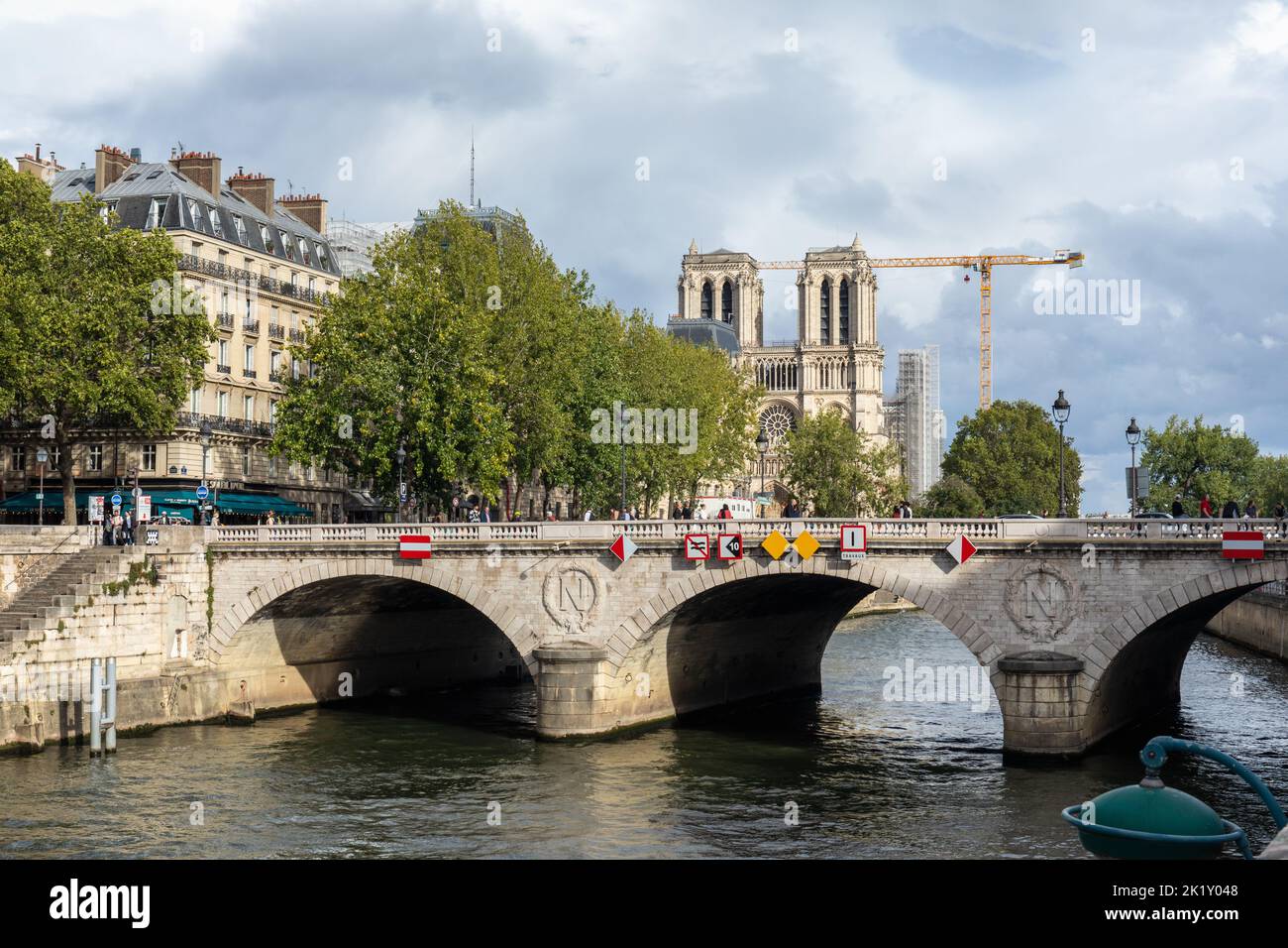Pont Saint-Michel steinerne Brücke über die seine mit einem Kran im Hintergrund für den Wiederaufbau der Kathedrale Notre Dame, Paris, Frankreich. 2022 Stockfoto