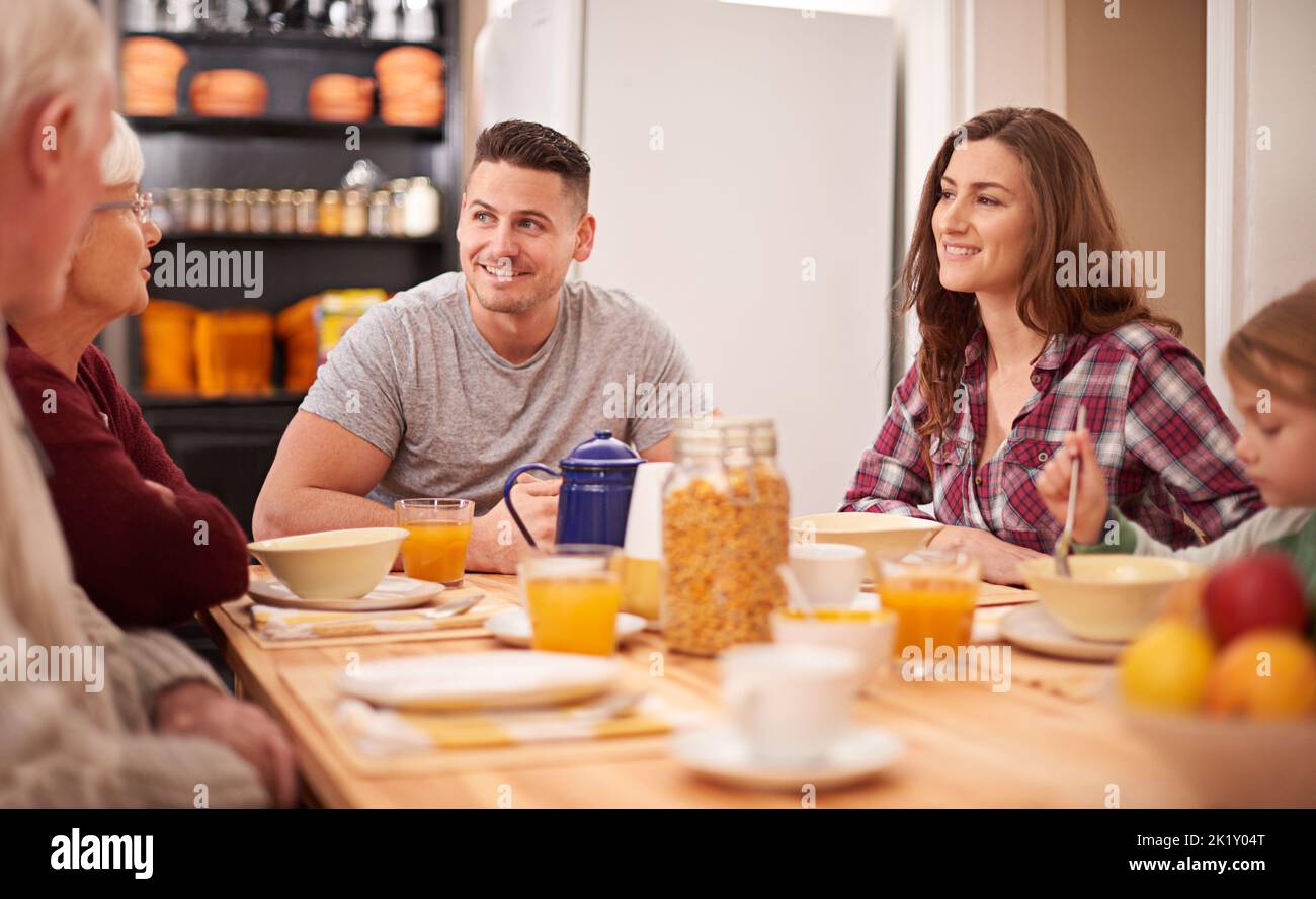 Teilen Sie eine Mahlzeit als Familie. Eine Multi-Generationen-Familie genießen das Frühstück zusammen in der Küche. Stockfoto