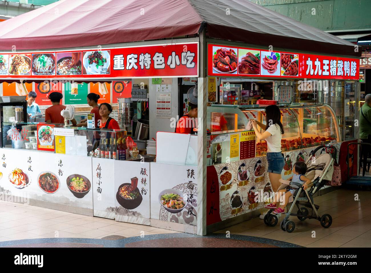 Frau kauft Lebensmittel vom Straßenstand in Chinatown, Singapur Stockfoto