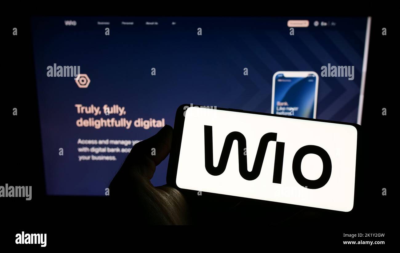 Person, die das Smartphone mit dem Logo des Finanzdienstleisters Wio Bank PJSC auf dem Bildschirm vor der Website hält. Konzentrieren Sie sich auf die Telefonanzeige. Stockfoto