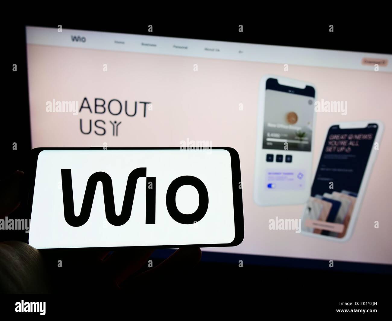 Person, die Mobiltelefon mit dem Logo des Finanzdienstleisters Wio Bank PJSC auf dem Bildschirm vor der Business-Webseite hält. Konzentrieren Sie sich auf die Telefonanzeige. Stockfoto