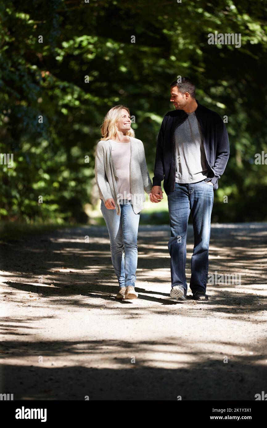 Gemeinsam durch das Leben gehen. Eine junge Frau blickt liebevoll auf ihren Freund, während sie einen Tag draußen genießt. Stockfoto