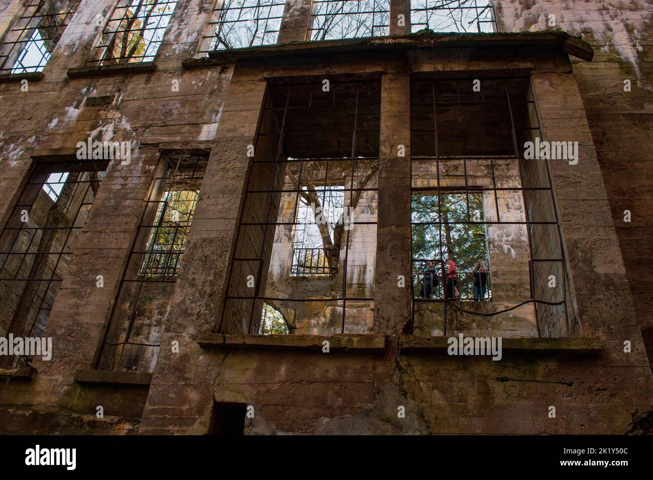 Ein Blick durch die Ruinen einer alten Mühle, Fenster zur Natur und zu Touristen; durch das schauende Glas. Stockfoto