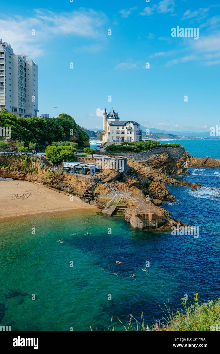 Biarritz, Frankreich - 24. Juni 2022: Einige Leute genießen das Wasser am Plage du Port Vieux Strand in Biarritz, Frankreich, am frühen Morgen Stockfoto