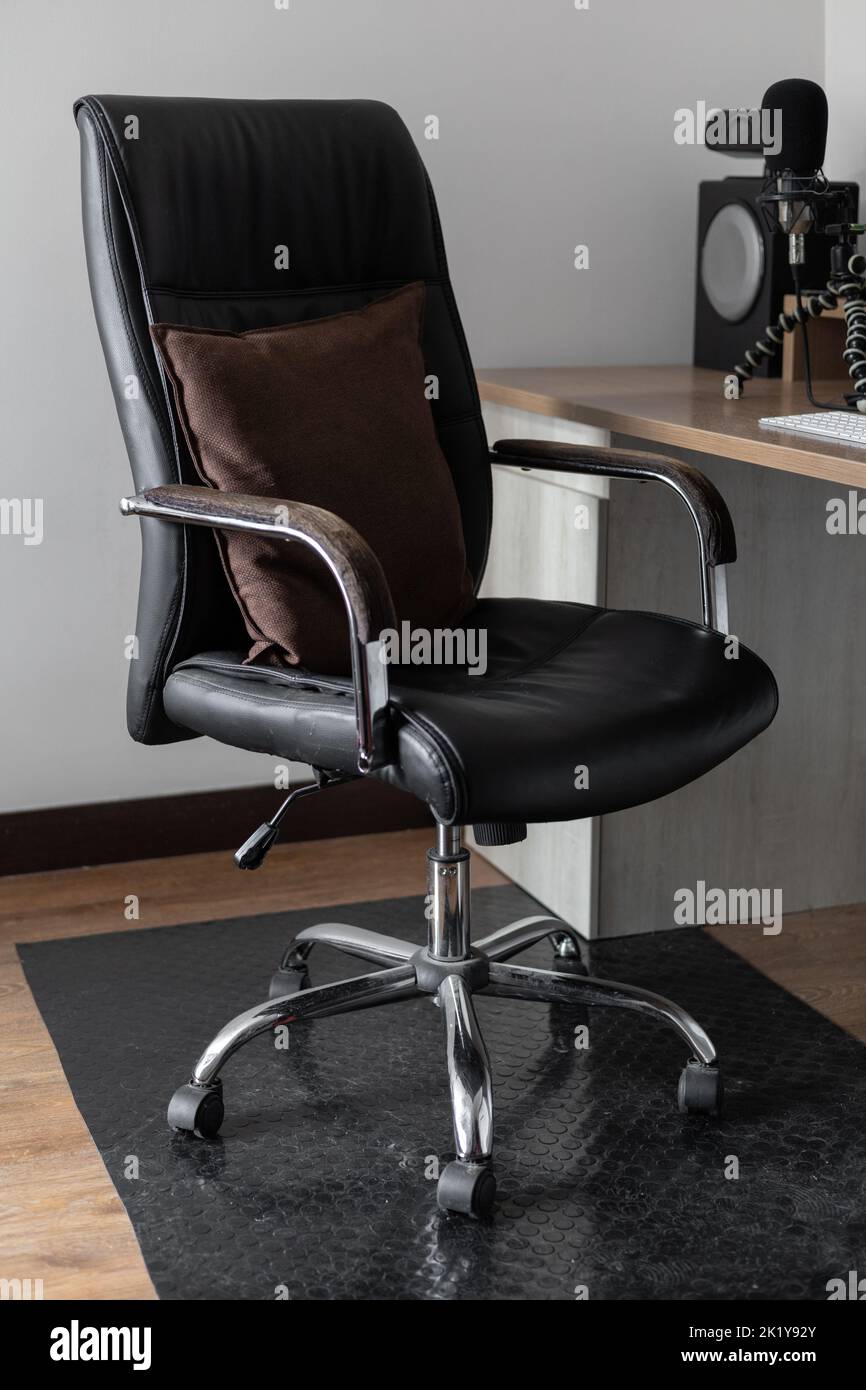 Bürodrehstuhl auf Rädern, ergonomisches und schwarzes Leder, in einem Büroinnenraum, Arbeitsplatz, Möbel Stockfoto