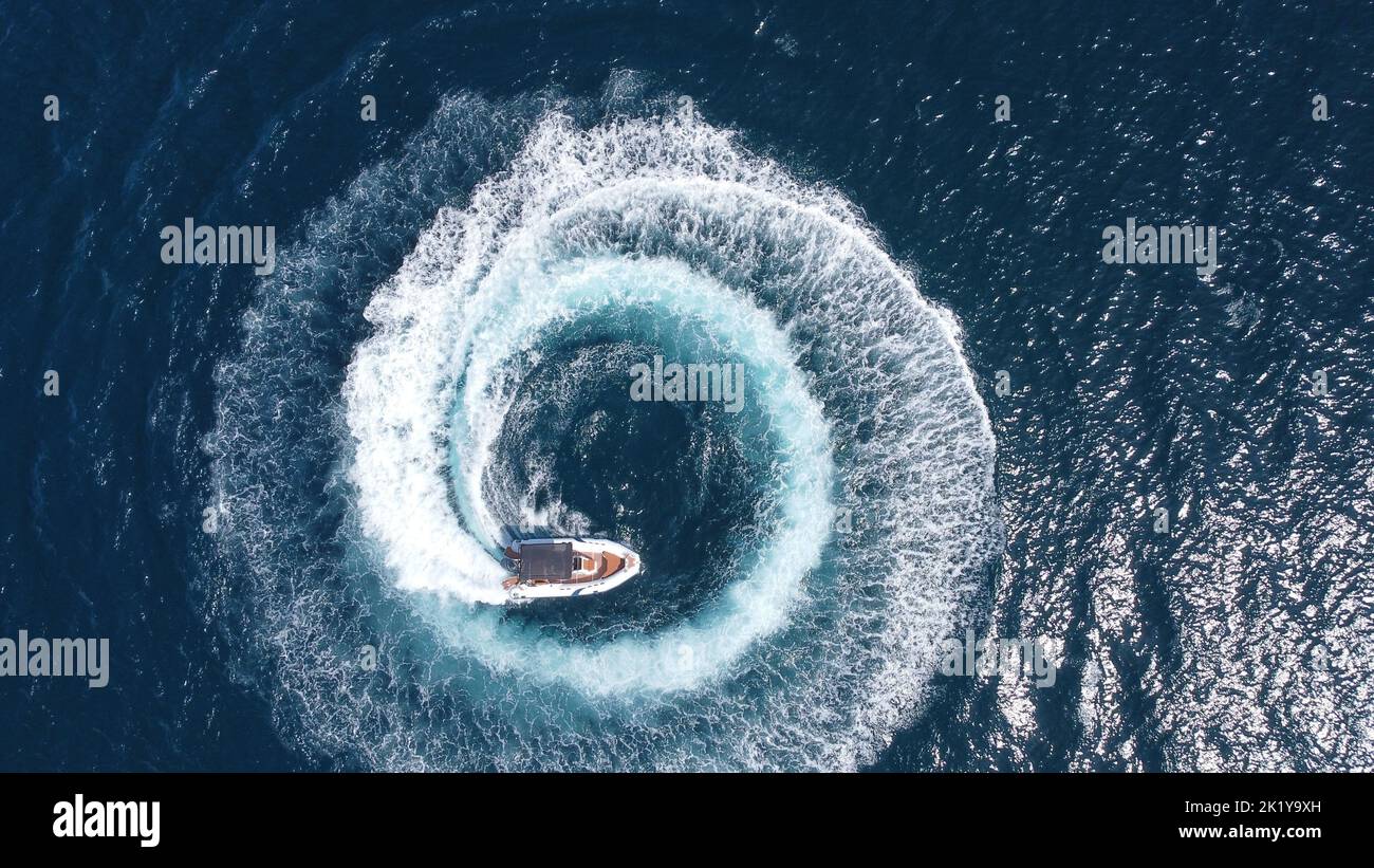 Eine Luftaufnahme einer Yacht, die in einem Kreis auf dem Meerwasser unterwegs ist Stockfoto